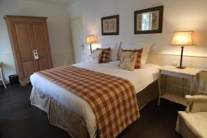 a bedroom with a bed with a plaid blanket at Pand 17 - Charming Guesthouse in Bruges