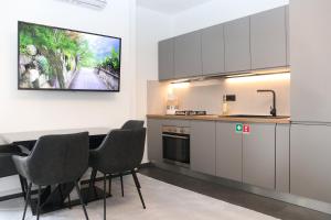 una cucina con tavolo e TV a parete di Luxury Pure! Bazzoni 2-room Suite, fully equipped a Olbia