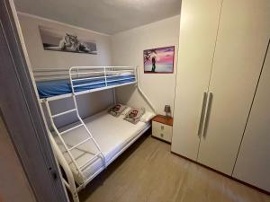 a small bedroom with a bunk bed and a refrigerator at Nathan house Pistis in Torre Dei Corsari