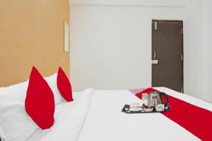a bedroom with a white bed with red pillows at Super OYO Flagship Sapphire Homes Stay in Hinjewadi