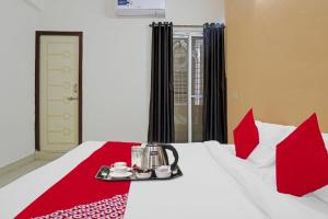 a hotel room with a bed with a tray of food on it at Super OYO Flagship Sapphire Homes Stay in Hinjewadi