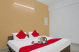 a hotel room with a bed with red pillows at Super OYO Flagship Sapphire Homes Stay in Hinjewadi