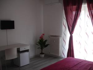Un dormitorio con una cama y una ventana con una planta en Le Gemelle, en Bari