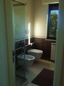a bathroom with a toilet and a glass shower at Casa Carolina Santa Maria in Montebello di Bertona