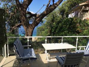 three chairs and a table on a deck with a tree at Mediterranean Beach House in Perazića Do