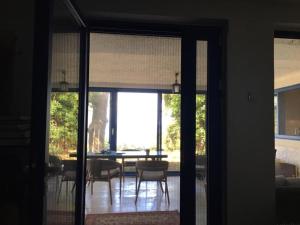 a dining room with a table and a glass door at Mediterranean Beach House in Perazića Do +10 photos