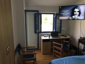 a bedroom with a desk with a laptop and a window at Mediterranean Beach House in Perazića Do