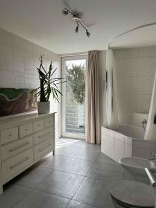 baño blanco con bañera, lavabo y tubermott en House Susanne en Colonia