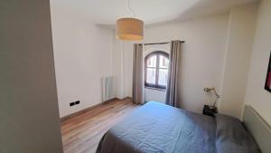 a bedroom with a bed and a large window at Domus Acaja in Pinerolo