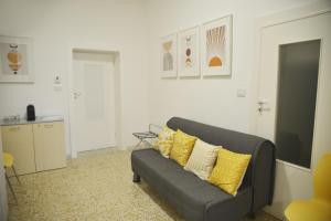 ein Wohnzimmer mit einem grauen Sofa und gelben Kissen in der Unterkunft La Casa di Eva in Brindisi