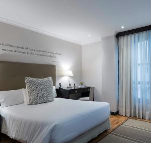 卡利的住宿－阿菲雷茲姆維奇酒店，卧室配有白色的床、书桌和窗户。