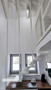 a white room with two windows and a staircase at Stone build suite with private pool in Kolios