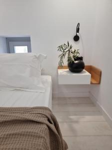 a bedroom with a bed and a plant on a table at Stone build suite with private pool in Kolios