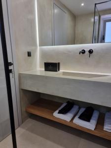 a bathroom with a shelf with towels and a mirror at Stone build suite with private pool in Kolios