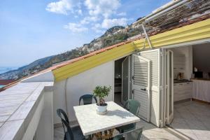 a balcony with a table and chairs on a roof at Grandmother's Attic in Furore