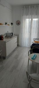 una cocina con armarios blancos y una mesa con sillas. en Le Gemelle, en Bari