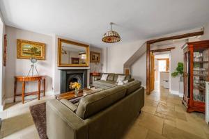 a living room with a couch and a fireplace at Fox Cottage, within 5 min walk of Bicester Village in Bicester
