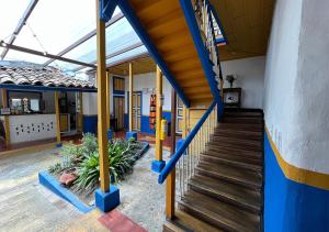 un pasillo de una escuela con paredes y escaleras azules y amarillas en Hostal Ciudad de Segorbe, en Salento