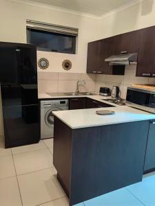 a kitchen with brown cabinets and a blue counter top at Classy and cosy Apt - Dainfern in Fourways