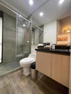 a bathroom with a toilet and a glass shower at Movistar Apartasuites in Bogotá
