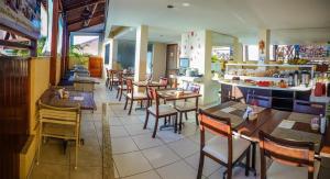 um restaurante com mesas e cadeiras e um balcão em Marsallis Residence Flat-EFM601 em Natal