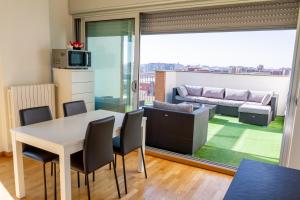 sala de estar con mesa, sillas y sofá en Terrazza Panoramica SleepInMilan, en Sesto San Giovanni