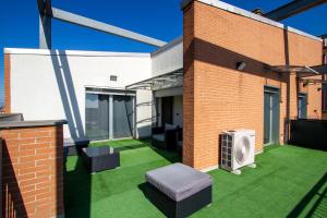 a patio with green grass and a brick building at Terrazza Panoramica SleepInMilan in Sesto San Giovanni