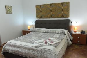 a bedroom with a bed with towels on it at Hotel California in Carloforte