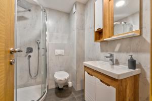 Un baño con ducha, inodoro y lavabo. en Apartman Viktor & Matej Zlatibor, en Zlatibor 15 fotos más