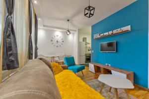 Una sala de estar con un sofá y una pared azul. en Apartman Viktor & Matej Zlatibor, en Zlatibor