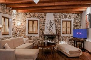 a living room with a stone wall at Tramonto Villa in Lagoúdi Zía