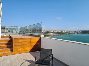 a chair on a balcony with a view of the water at Cazinos Apartamento in Praia