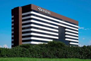 a building with a sign on the top of it at Sheraton DFW Airport Hotel in Irving