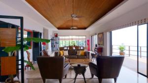 ein Wohnzimmer mit einem Sofa und einem Deckenventilator in der Unterkunft Fah Suay Villa - Incredible & Spacious 5 Bedrooms in Mae Nam