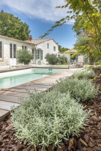 a backyard with a swimming pool and a wooden deck at LE SECRET in Saint-Martin-de-Ré
