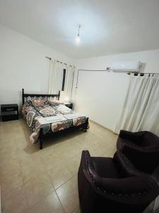 Un dormitorio con una cama y una silla dentro. en Raices Diaguitas, en Vinchina