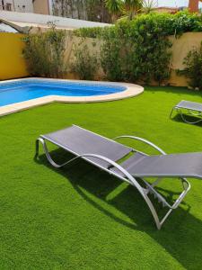 una mesa de picnic en el césped junto a una piscina en Matalascañas en Matalascañas