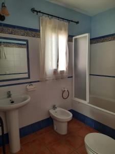 een badkamer met een wastafel, een toilet en een bad bij Matalascañas in Matalascañas