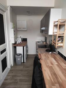 een keuken met een houten aanrecht in een kamer bij residence julius aéroport tillé classé 3 étoiles in Tillé