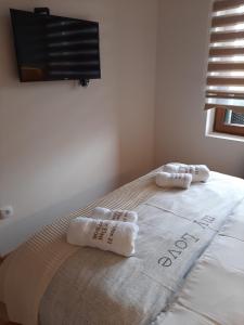 a bedroom with a bed with two towels on it at Apartman 21 Vila Elsa III Zlatibor in Zlatibor