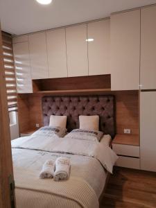 1 dormitorio con 1 cama grande y 2 toallas. en Apartman 21 Vila Elsa III Zlatibor en Zlatibor