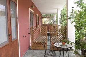 a patio with a table and chairs on a porch at Hotel California in Carloforte