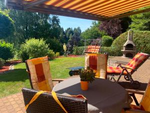 eine Terrasse mit einem Tisch, Stühlen und einem Grill in der Unterkunft Ferienwohnung Rennsteigblick in Suhl