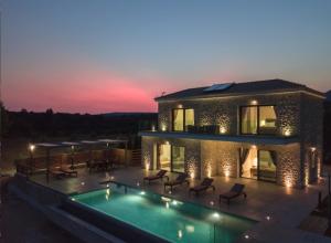 a house with a swimming pool in front of it at Kefalonia Stone Villas - Villa Petros Kefalonica in Trapezaki