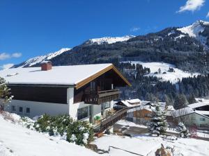 una casa en la nieve con una montaña en Bergjuwel Kleinwalsertal, en Hirschegg