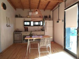 cocina con mesa, sillas y nevera en La Pausa Casa Rural en A. de la Cruz