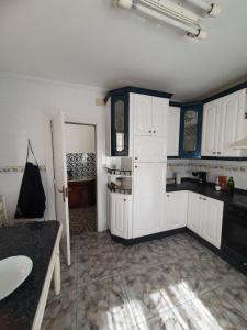 a kitchen with white cabinets and a table in it at La Llave 