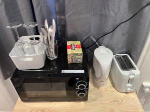 un mostrador con microondas y otros electrodomésticos en Y2 guest house, en Londres