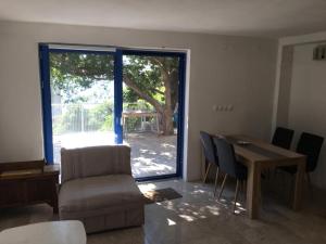 uma sala de estar com um sofá, uma mesa e uma janela em Lovely studio apartment on Montenegro Beach Side em Perazića Do