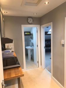 a kitchen with a sink and a clock on the wall at Dove House in Congleton